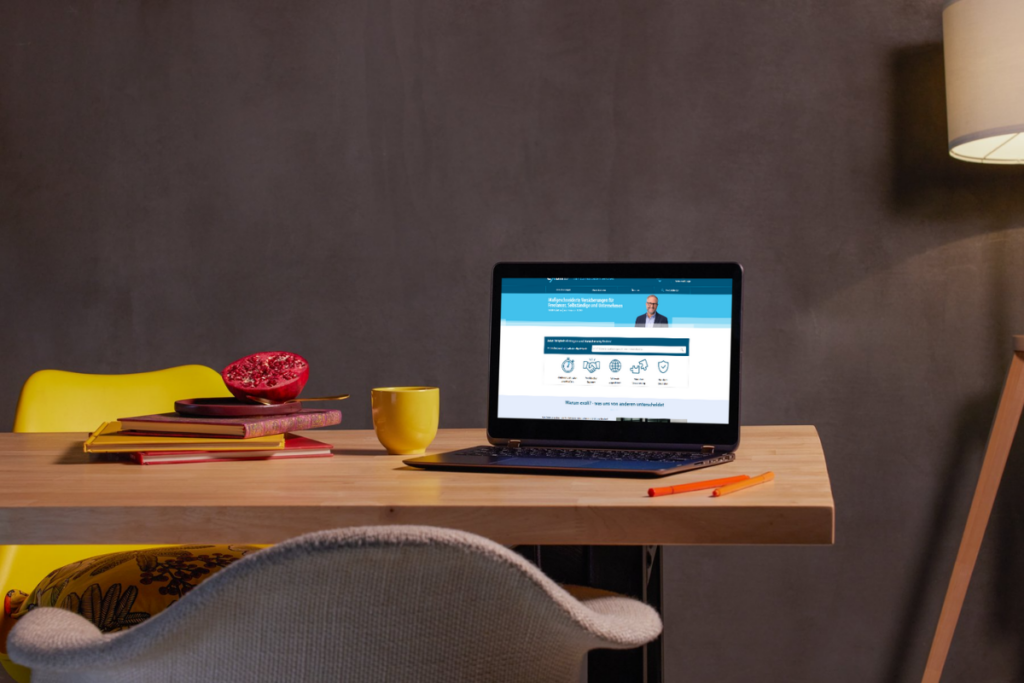 Freelancer schließt Berufshaftpflicht online ab am Laptop