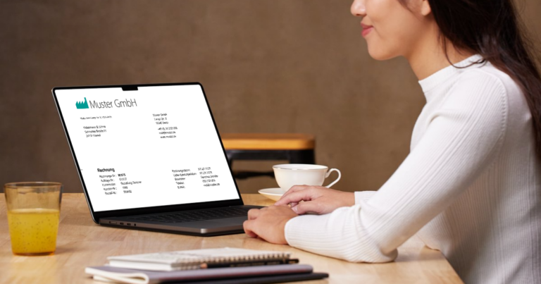 Freelancerin schreibt Rechnung am Laptop mit allen Pflichtangaben nach § 14 UStG